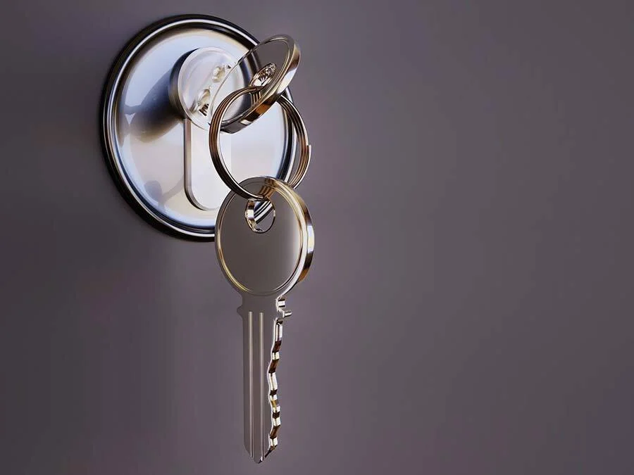 Ein Schlüssel steckt in einem Türschloss.