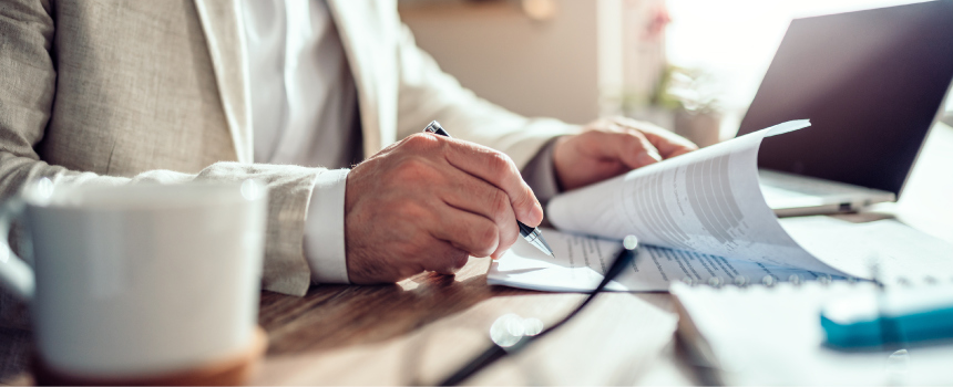 Ein Mieter unterschreibt einen Mietvertrag. Er schließt den Mietvertrag schriftlich ab.