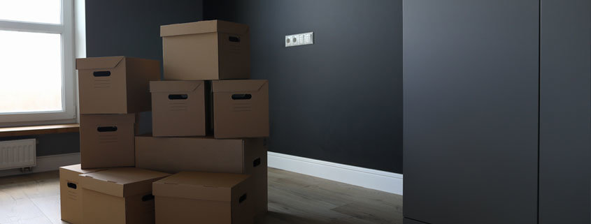 Umzugskisten in einer leeren Wohnung. Muss der Partner ohne Mietvertrag ausziehen.
