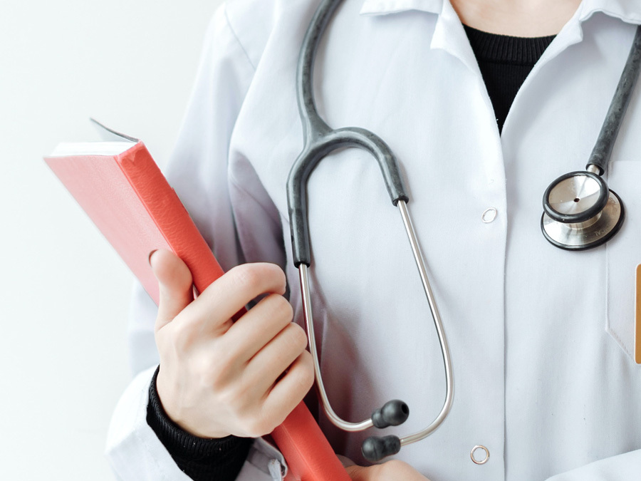 Eine Ärztin hält eine Mappe mit Patientendaten in der Hand.