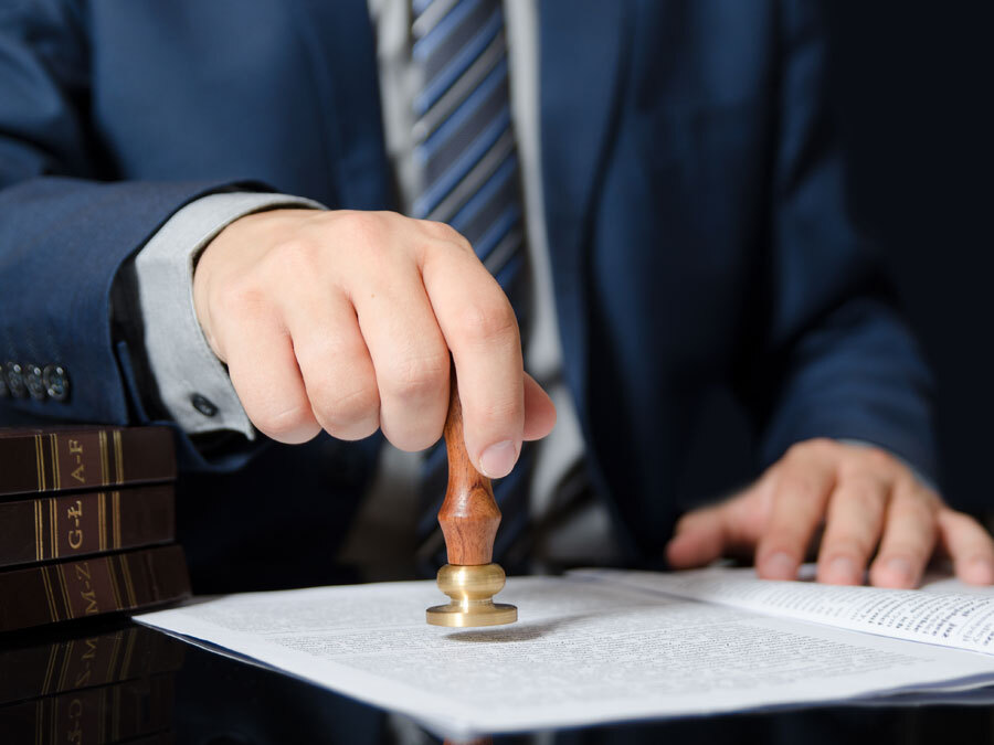 Ein Notar setzt sein Siegel unter einen Erbvertrag.