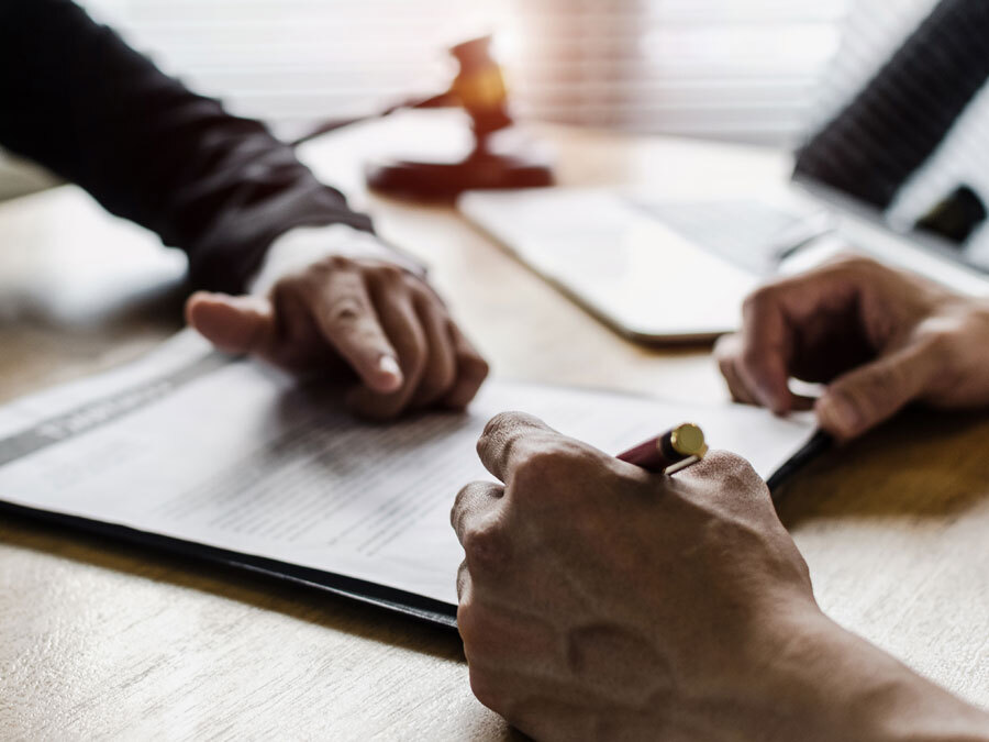 Ein Arbeitgeber zeigt auf die Unterschrift auf einer Kündigung in der Kurzarbeit.