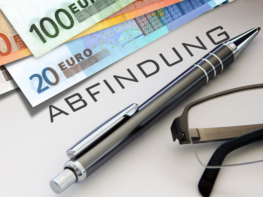 Auf dem Tisch liegt ein Abfindungsvertrag. Daneben Geldscheine und ein Stift zum Unterzeichnen. Eine Brille symbolisiert, dass man den Vertrag gut prüfen sollte.