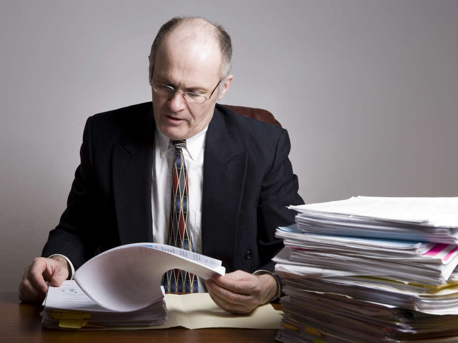 Ein Unternehmer blättert ins seinen Geschäftsunterlagen.