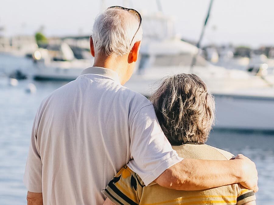 Ein älteres Paar steht am Hafen.