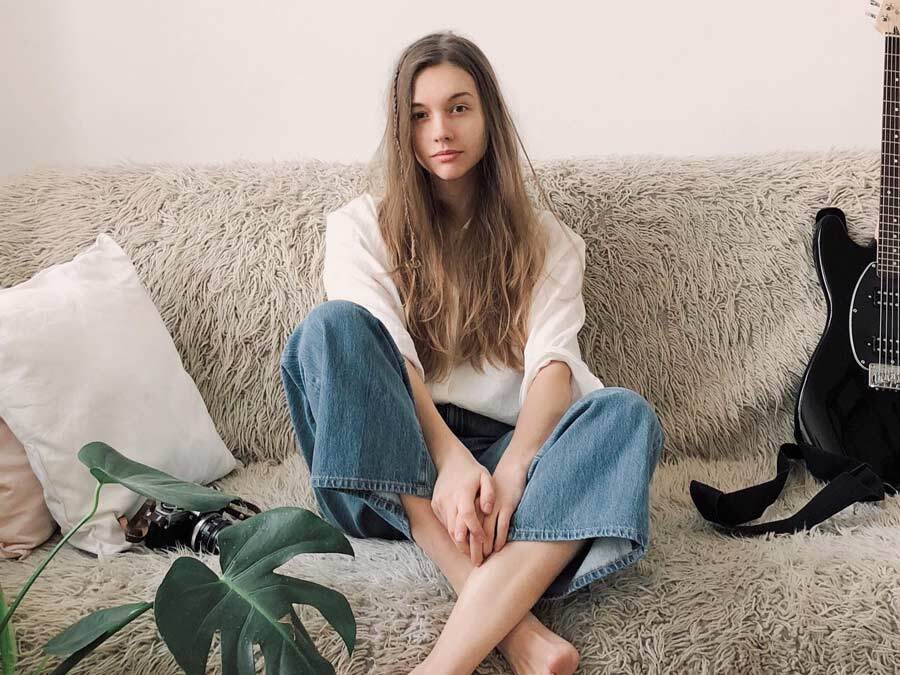 Eine junge Frau sitzt auf einem Sofa.