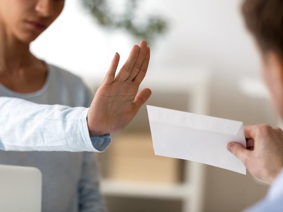 Annahmeverweigerung der Kündigung. Eine Frau weist mit der Hand einen Brief zurück.