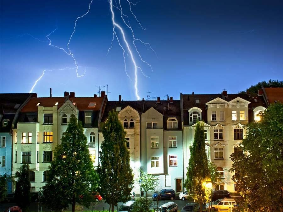 Ein Unwetter zieht über eine Reihe von Miethäusern hinweg.