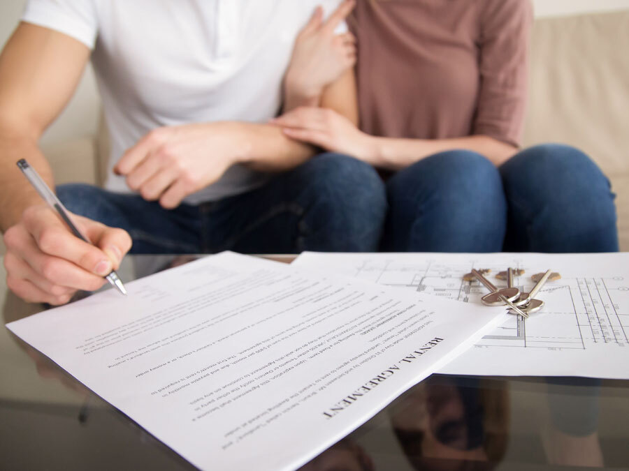 Ein Paar unterschreibt einen Mietvertrag. Sind die 10 wichtigsten Punkte im Mietvertrag enthalten?