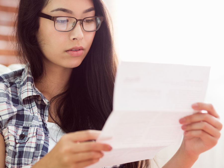 Eine Frau mit Brille hält ein Schreiben in der Hand. Es ist eine Datenschutz Einwilligung.