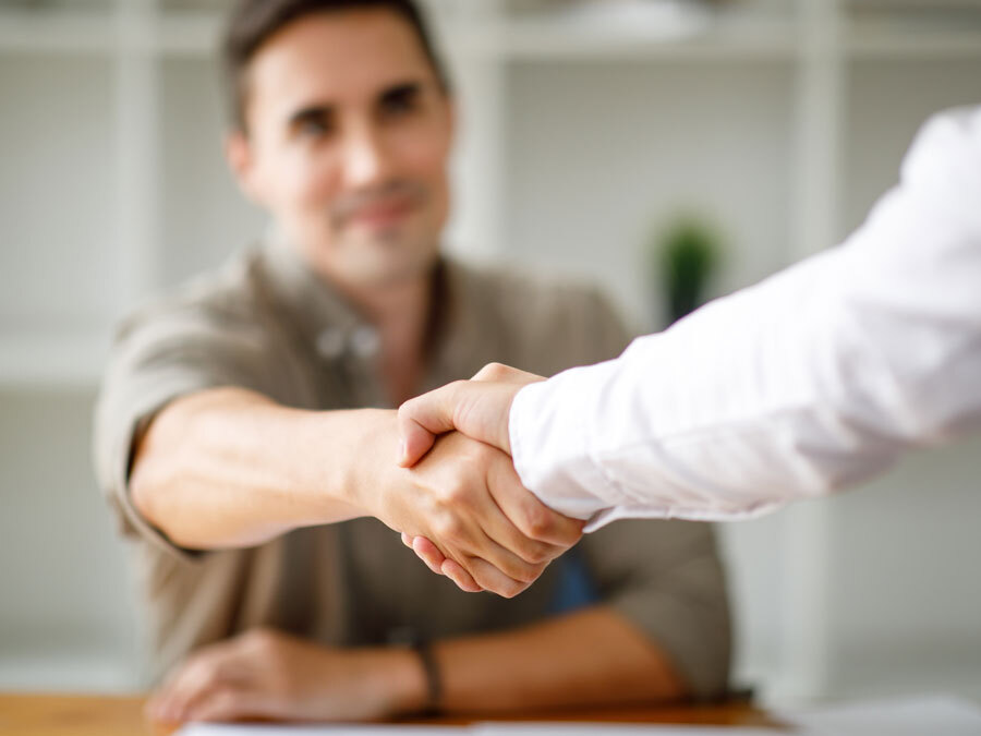 Ein Handshake bei Gehaltsverhandlungen zwischen Arbeitnehmer und Arbeitgeber.