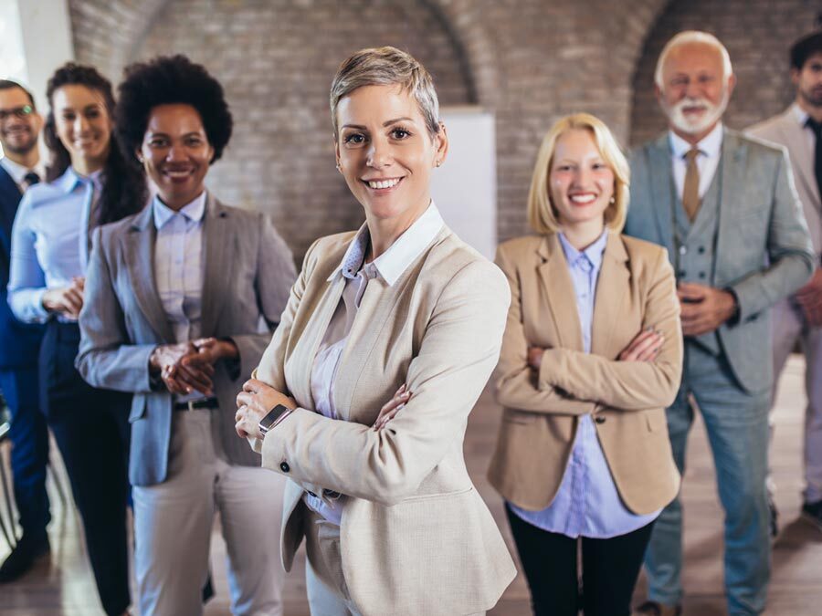 Eine Gruppe von Arbeitnehmern steht zusammen und sieht glücklich aus.