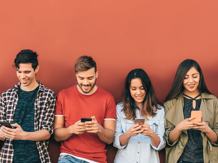 Junge Leute schauen auf ihr Smartphone.