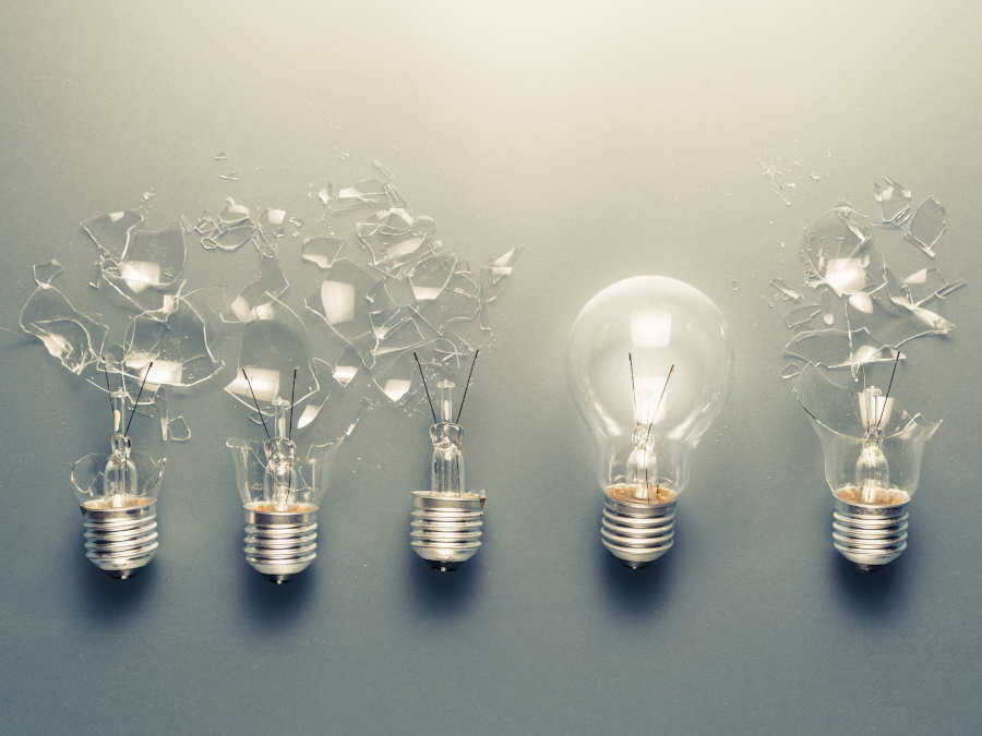 Eine perfekte Glühbirne zwischen vier kaputten Glühbirnen.