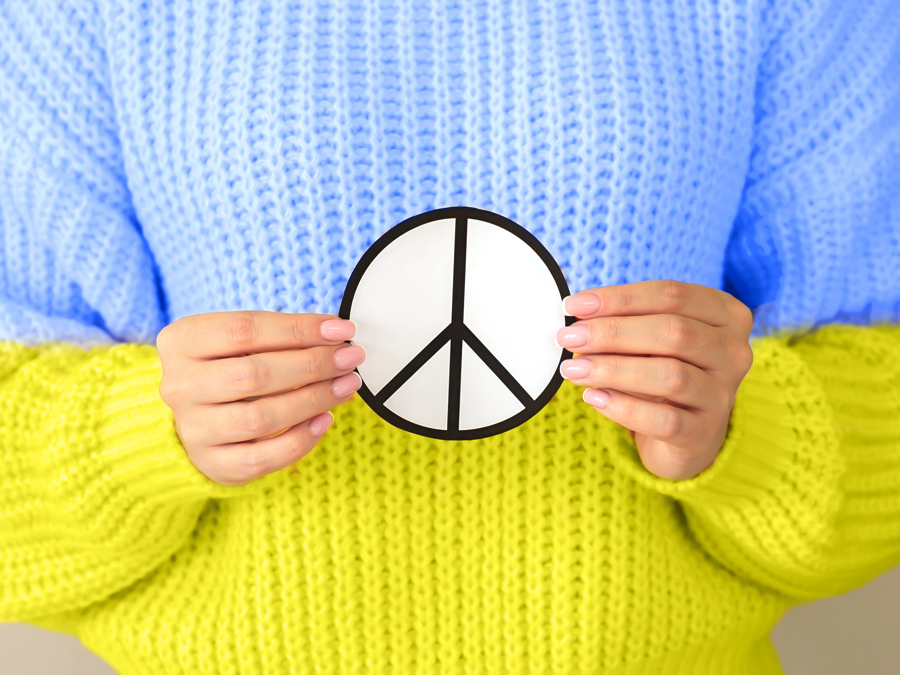 Eine Person trägt eine Pulli in den Farben der ukrainischen Fahne, um auf Spenden aufmerksam zu machen, wobei Sie diese Spenden von der Steuer absetzen können.