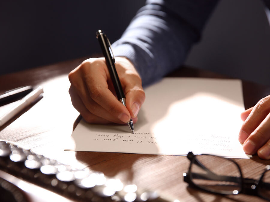 Ein Mann schreibt sein Testament auf Papier.