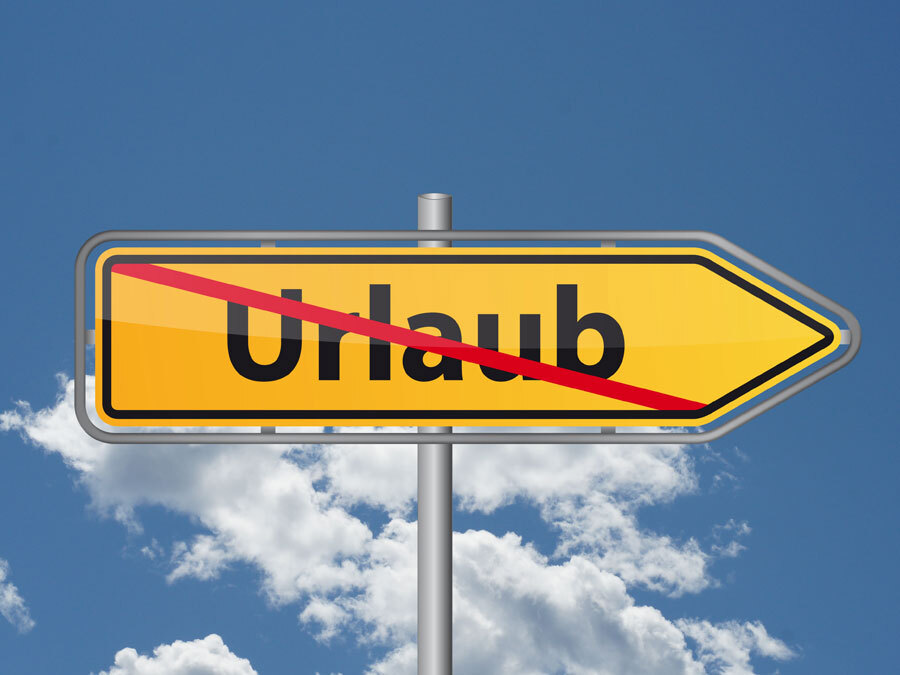 Ein durchgestrichener Wegweiser mit dem Wort Urlaub symbolisiert die Urlaubssperre.