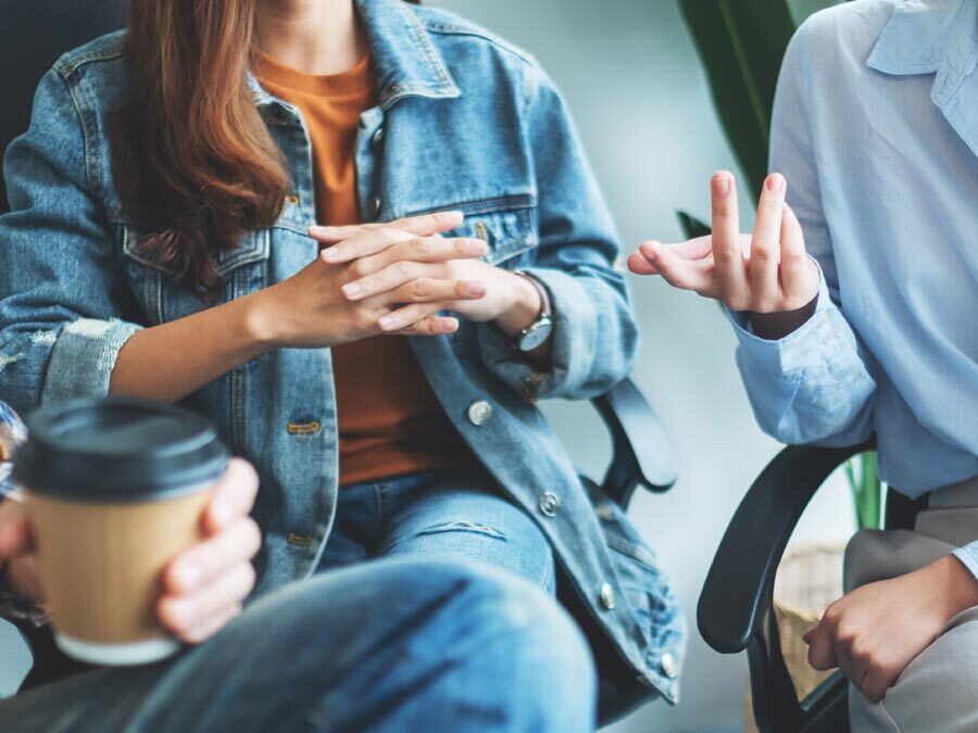 Arbeitskollegen achten auf ihre nonverbale Kommunikation im Beruf.