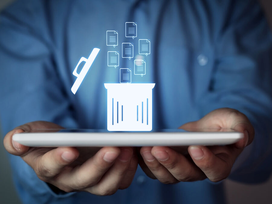 Ein Mann mit einen Laptop in der Hand. Darüber ein Papierkorb Symbol, das die Löschung von Daten veranschaulicht.