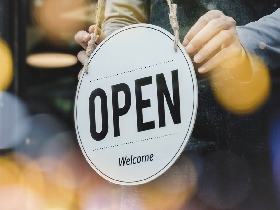 Ein Ladenschild mit der Aufschrift "open" hängt an der Tür.