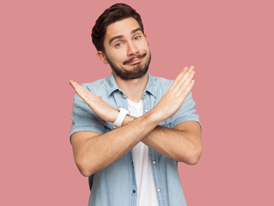 Ein junger Mann verschränkt die Arme.